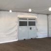 Air conditioning unit configured into the side wall of a rental tent.
