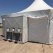 Closeup view of an air conditioning unit configured into the side wall of a rental tent.