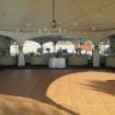 Large outdoor wedding tent with huge 24' x 27' wooden dance floor set up in the center.