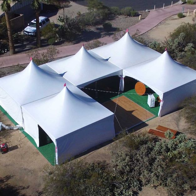 Green rental turf installed under rental tents to create soft surface for wedding reception.