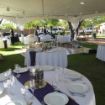 Purple linen table runners elegantly placed on a round wedding guest table.