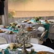 Turquoise linen table runners elegantly placed on a round wedding guest table.