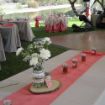 Salmon linen table runners elegantly placed on a round wedding guest table.