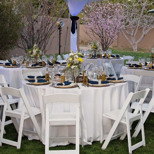 Round 120" white linen table cloth elegantly set up for a wedding celebration.