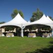 Twinkle lights placed on a Diamond Hexagon Wedding Tent with decorated guest tables under the canopy.