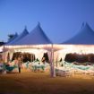Twinkle and globe lighting configured on a Hexagon 170 wedding rental tent with decorated guest and head tables.