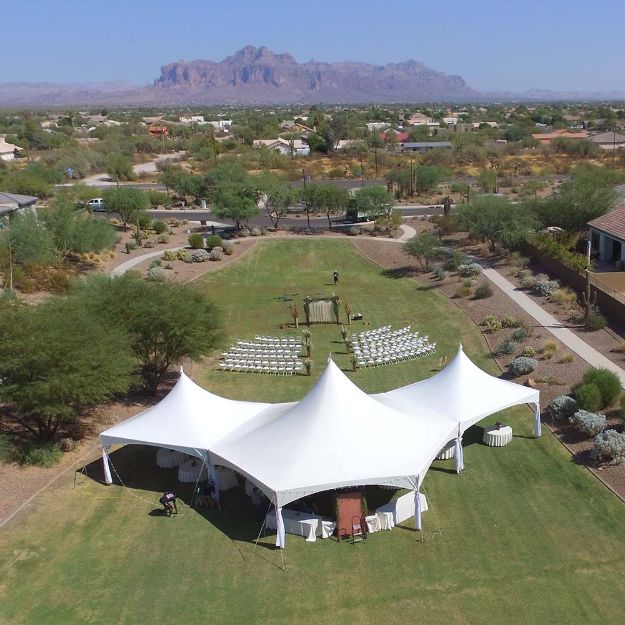 Grass area setup for a wedding and reception using a Hexagon 125 rental package and the Superstition Mountains behind.