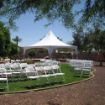 Early setup of a backyard wedding that includes a Hexagon 60 wedding tent and guest seating for the wedding ceremony.