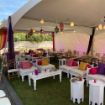 Elegant wedding under a 20' x 40' Rectangle Tent with seating area, guest tables, globe lights and customer lanterns.