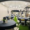 Elegant 2022 graduation party setup under a 20' x 50' Rectangular tent package with globe lights and guest tables.