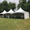 JMS party crew in the process of setting up a 20' x 60' Rectangle wedding tent package in a backyard with clouds behind.
