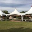Large dance floor in the center of a 20' x 60' Rectangular wedding tent package with guest tables left and right.