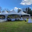 A wedding in the park configured using rental package of a Hexagon 170 wedding tent, guest chairs and tables.