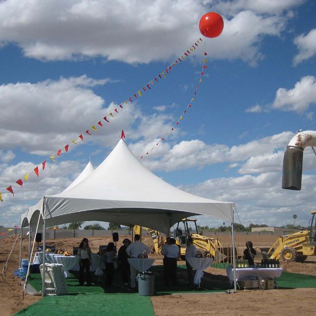 50 Guest groundbreaking tent rental package with heavy equipment in the background and guests enjoying the canopy cover.