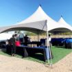 Ready to celebrate under a 20' x 40' Groundbreaking Tent Rental Package with blue and black linens.