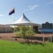 Grand opening tent setup on a new housing development with an Arizona flag flowing in the background.