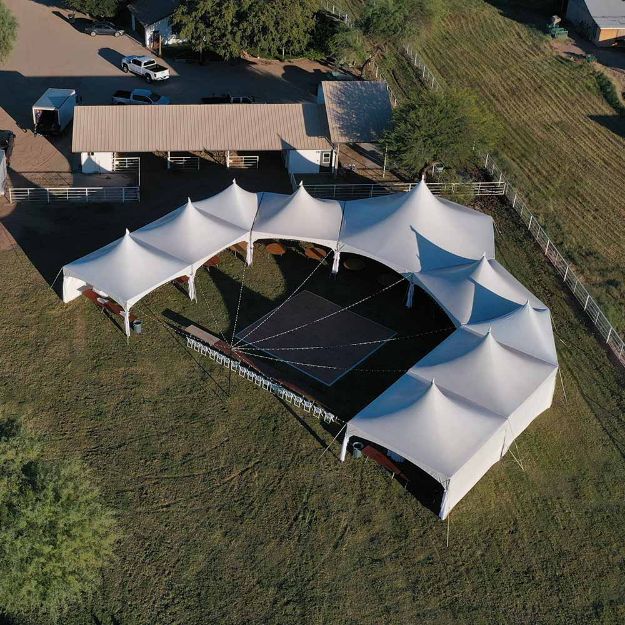 Aerial view of a DUTS XL 350 guest wedding tent package with dance floor and twinkle lights.