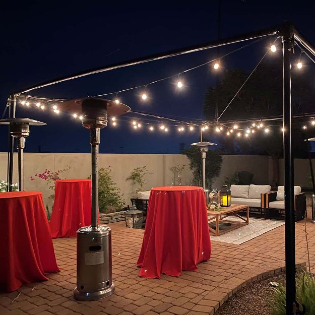 Fully configured EXO Tent with globe lighting lit up at night in a backyard.