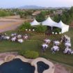 Aerial drone picture of two EXO Tents in front of a DUTS 150 wedding tent package lit up at dusk.