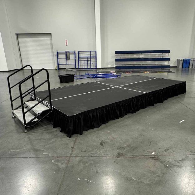 8' x 16' modular event stage with two 4' x 8' decks connected show from behind a podium setup for an event.